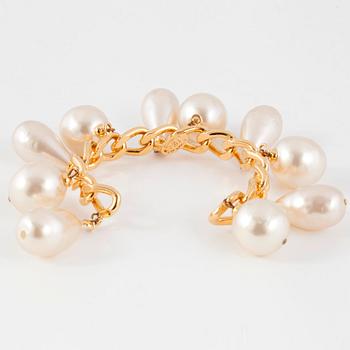CHANEL, a goldcolored bracelet with decorative pearls.