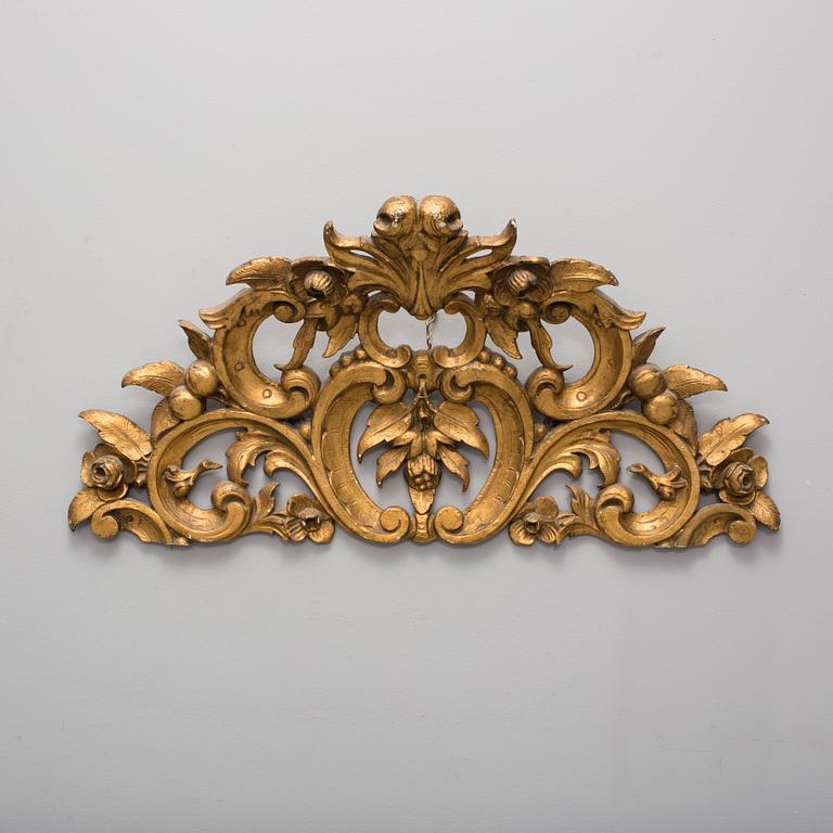 A late 19th century gilt rokoko style carved wooden ornament.