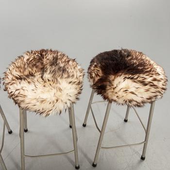 A set of four modern stolls with sheepskin.