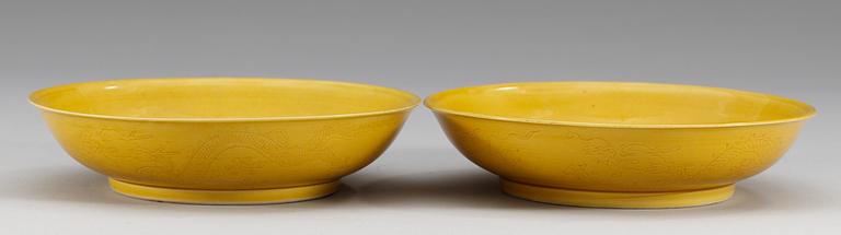 A pair of yellow-glazed incised dragon dishes, Qing dynasty with Qianlongs seal mark (1644-1912).