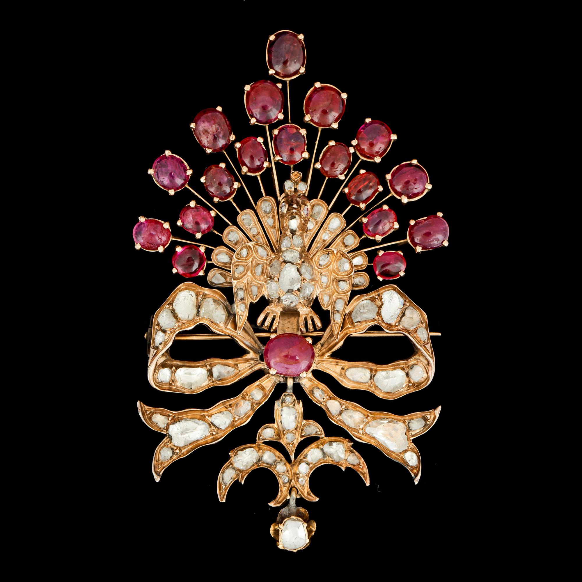 A cabochon ruby and rose cut diamond brooch, designed as a peacock.