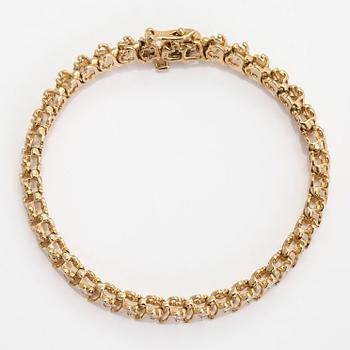 A 14K gold tennis bracelet, with brilliant-cut diamonds.