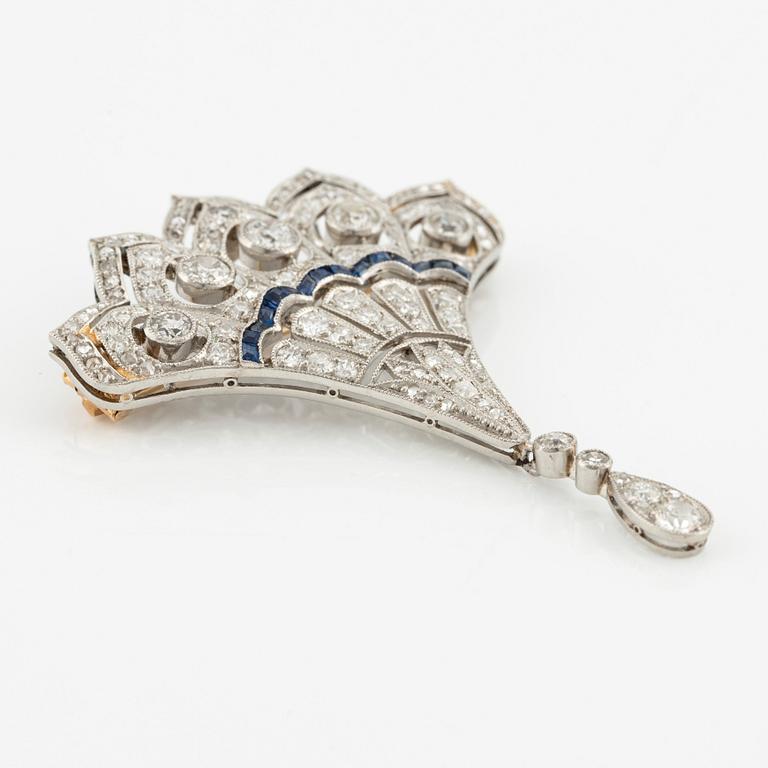 A platinum brooch with round brilliant, eight-, and rose-cut diamonds and calibré-cut sapphires.