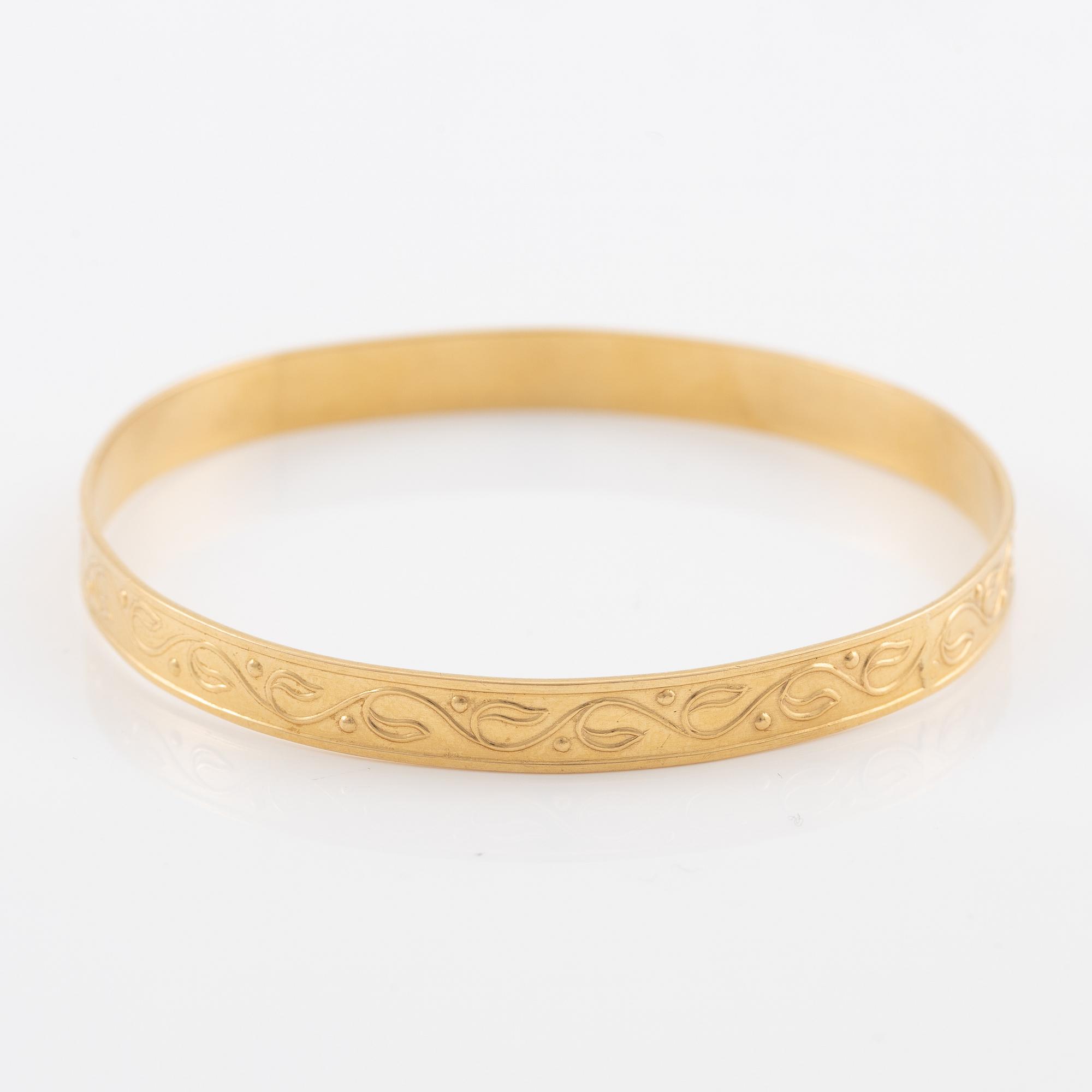 Arm ring, 18K gold with stylised decoration.