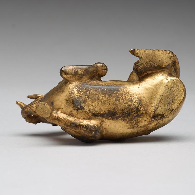 A gilt bronze figure of a reclining mythical animal, Qing dynasty, 19th Century.