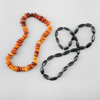 HALSBAND, 2 st, jaspis och oslipad bärnsten, 1900-talets andra hälft.