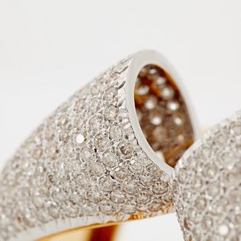 An 18K gold bangle set with round brilliant-cut diamonds.