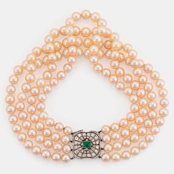 990. A four strand cultured pearl necklace with an 18K white gold clasp set with a faceted emerald.