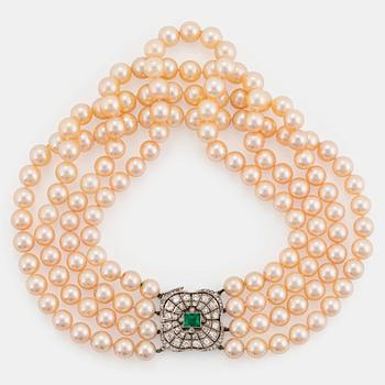 990. A four strand cultured pearl necklace with an 18K white gold clasp set with a faceted emerald.