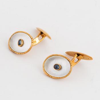 18K gold cufflinks with mother of pearl and cabochon-cut sapphire.