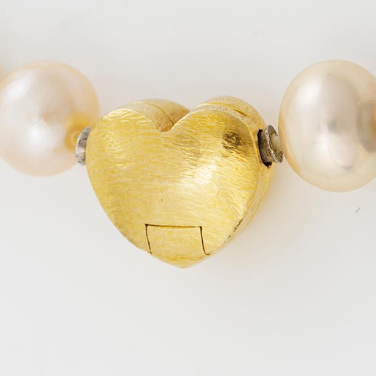 Ole Lynggaard clasp in 18K gold with a round brilliant-cut diamond and a necklace of cultured freshwater pearls.