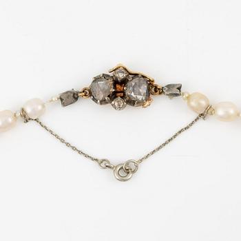 A pearl necklace clasp in silver and 18K gold with rose-cut diamonds.