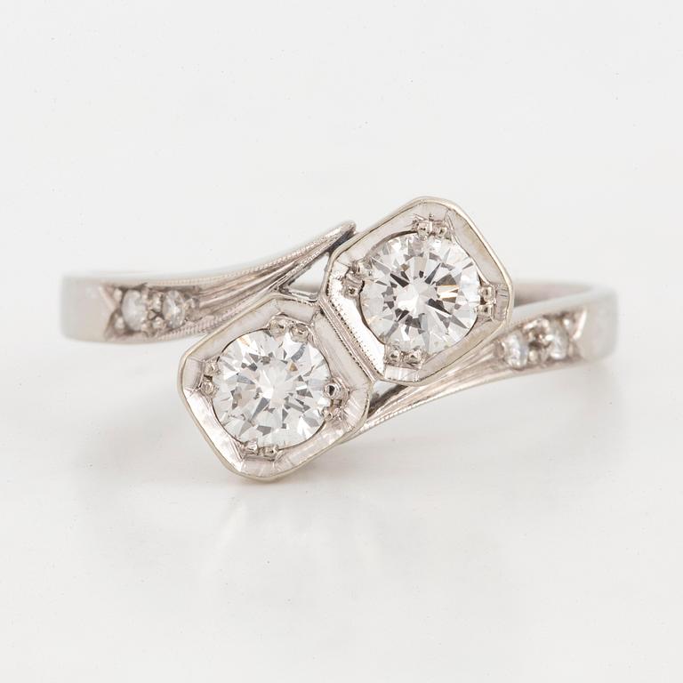 Brilliant-cut diamond crossover ring.