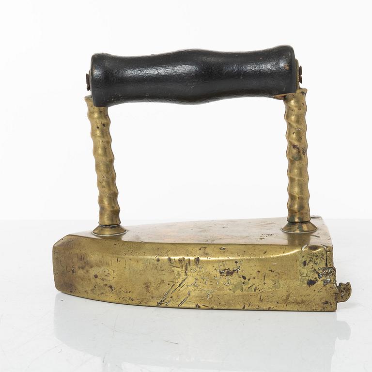 A brass clothes' iron, dated 1773.
