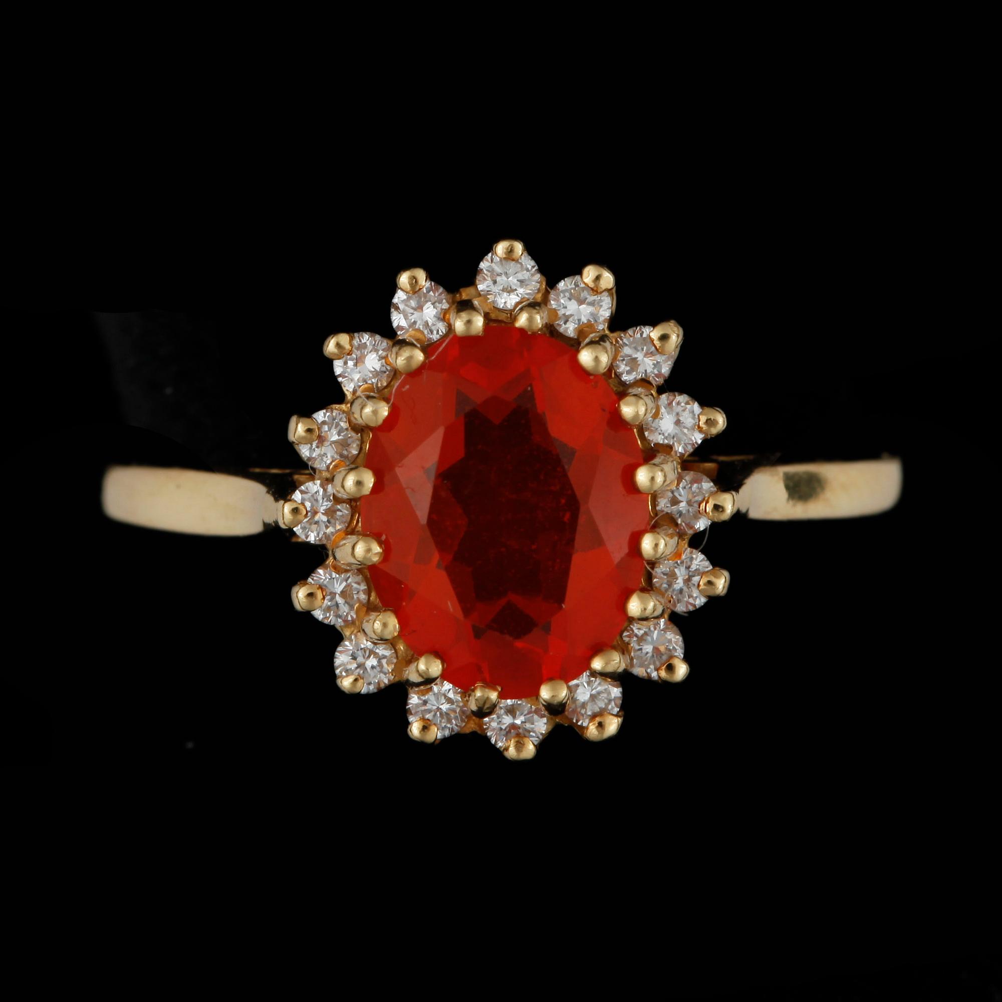 RING, 18k guld med eldopal och krans av 16 små briljantslipade diamanter, tot ca 0,16 ct. Vikt ca 4 gram.