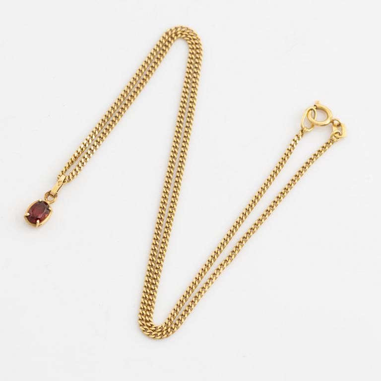 Pendant with chain with red stone, possibly garnet.