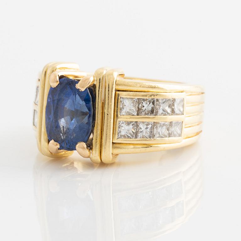 Ring in 18K gold set with an oval faceted sapphire and princess-cut diamonds.