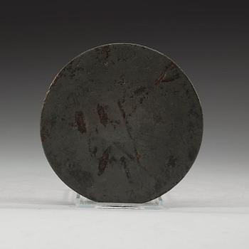 A bronze mirror decorated with characters a stylized dragon and tiger, Eastern Han dynasty (25-220).
