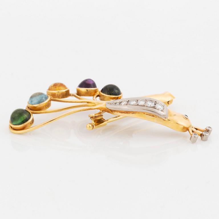 An 18K gold brooch in the form of a parrot with colored gemstones and round brilliant-cut diamonds.