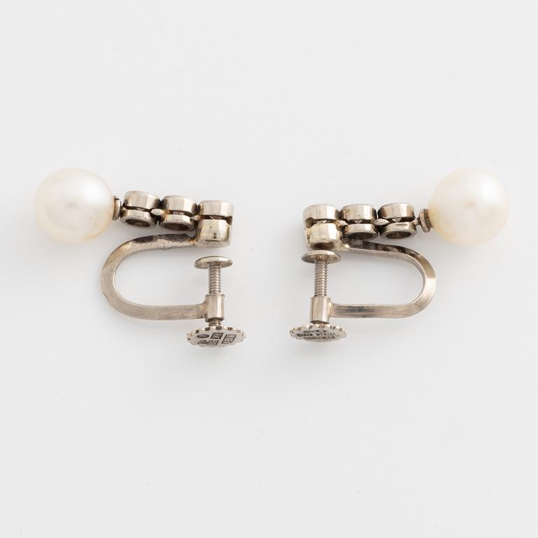 A pair of earrings in 18K white gold with round brilliant-cut diamonds and cultured pearls.