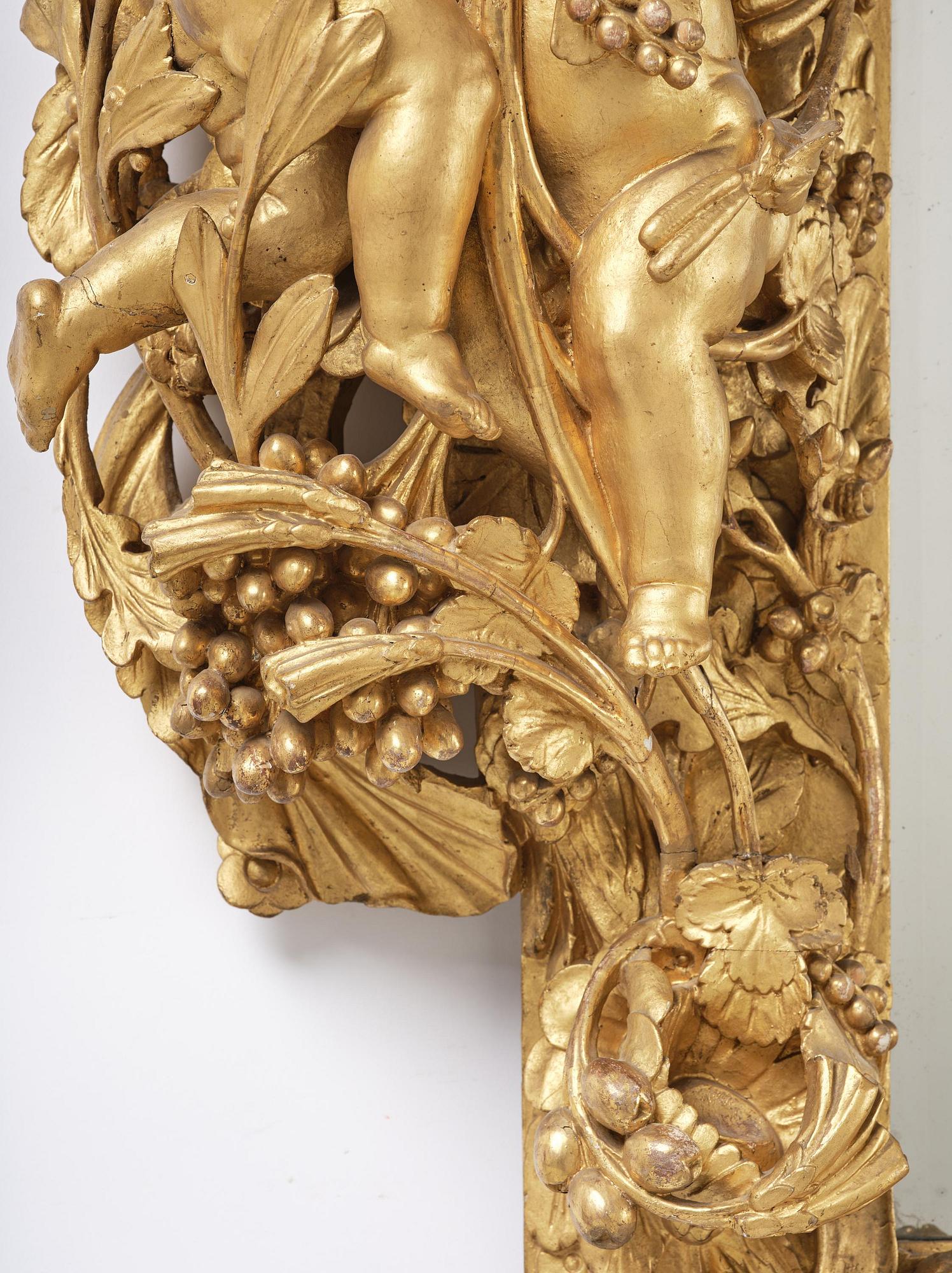 A presumably Dutch Louis XIV carved giltwood frame with mirror glass, in the style of Jean Le Pautre, late 17th century.