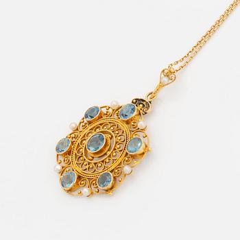 An 18K gold pendant set with faceted aquamarine and pearls.