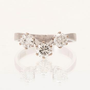 An 18K white gold ring/three stone ring set with round brilliant cut diamonds.