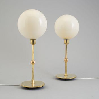 A pair of end of the 20th century bras and glass table lights.