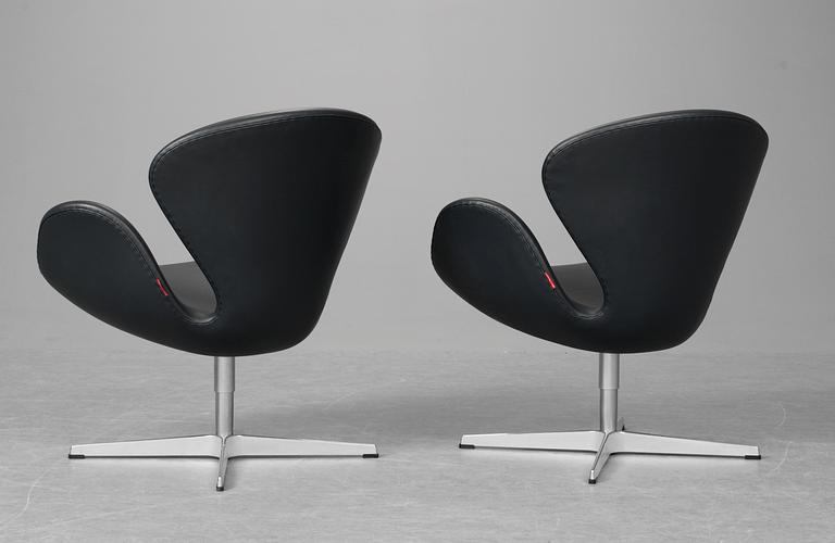 A pair of Arne Jacobsen dark grey leather "Swan" easy chairs, Fritz Hansen, Denmark 2008.