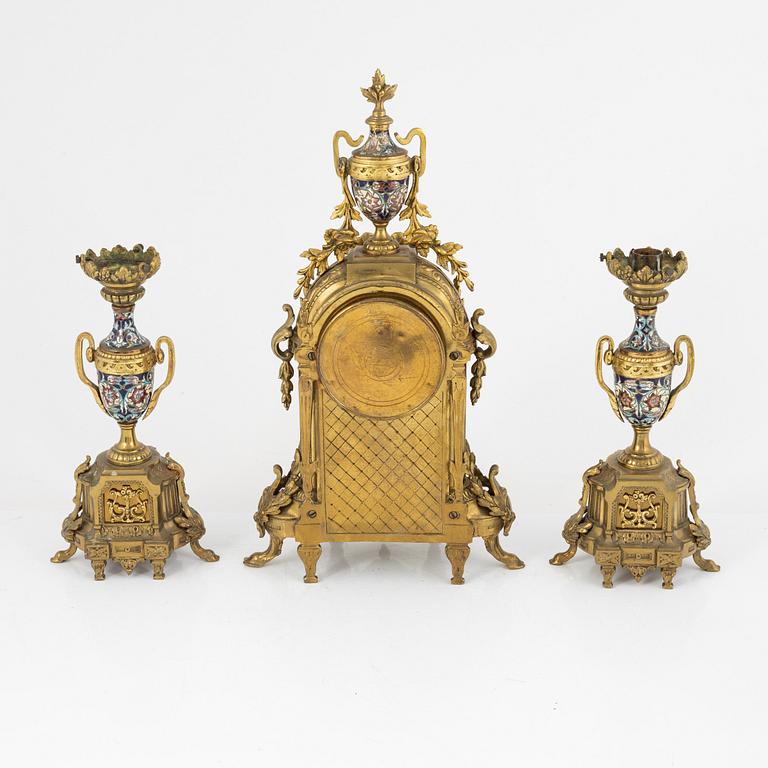 A set of two Louis XVI-style candle sticks and a mantle clock, late 19th century.