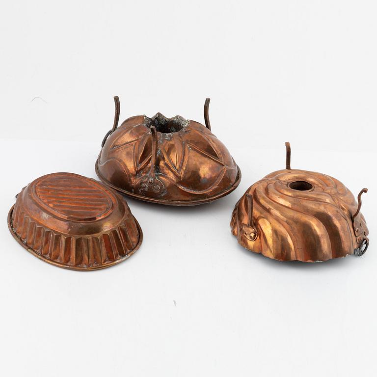 Four cake moulds, and a funnel, copper, 18th and 19th Century.