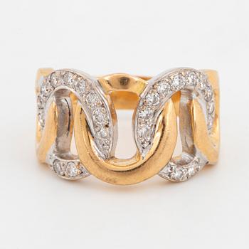 An 18K gold ring set with round brilliant-cut diamonds.