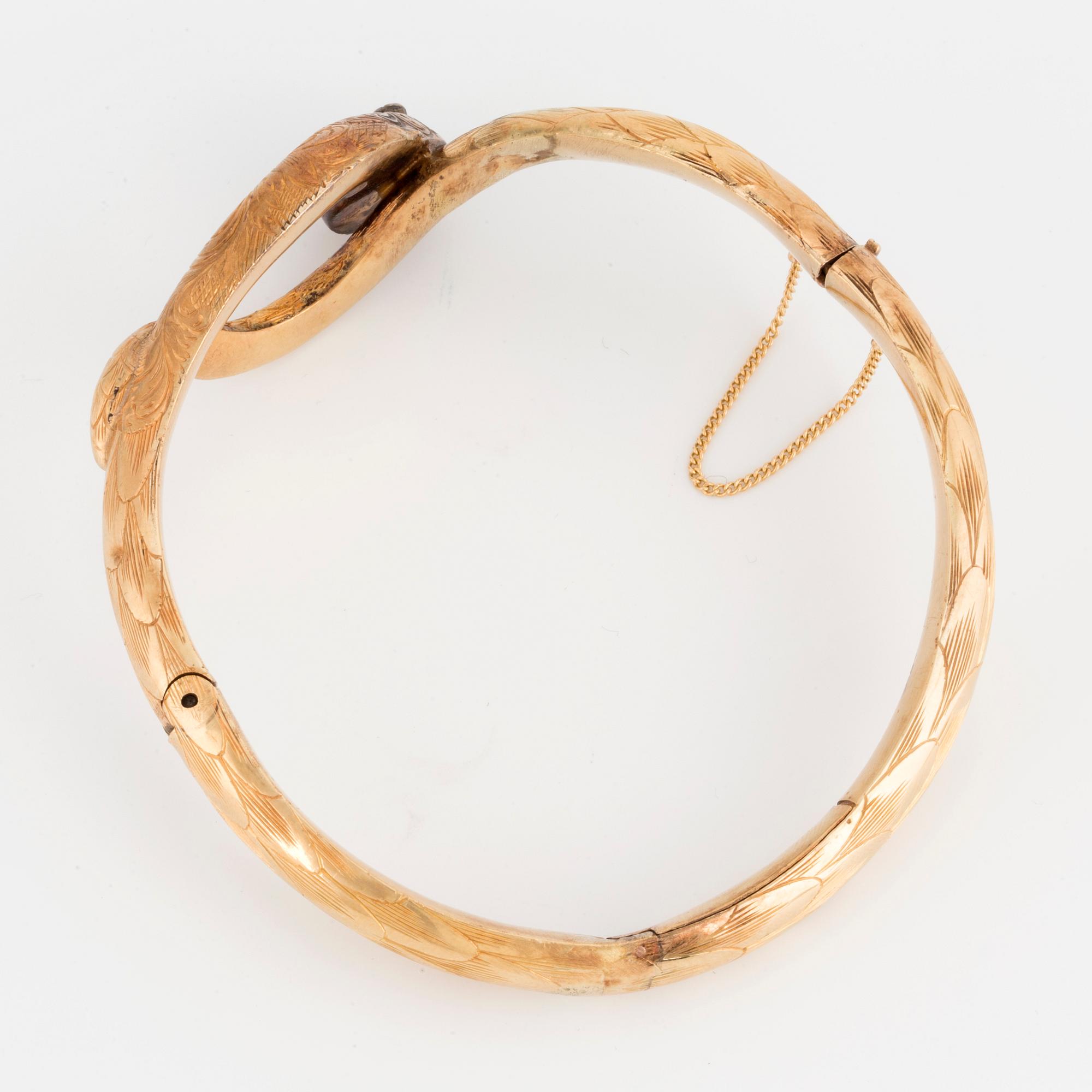 An 18K gold snake bangle with rose-cut diamonds.