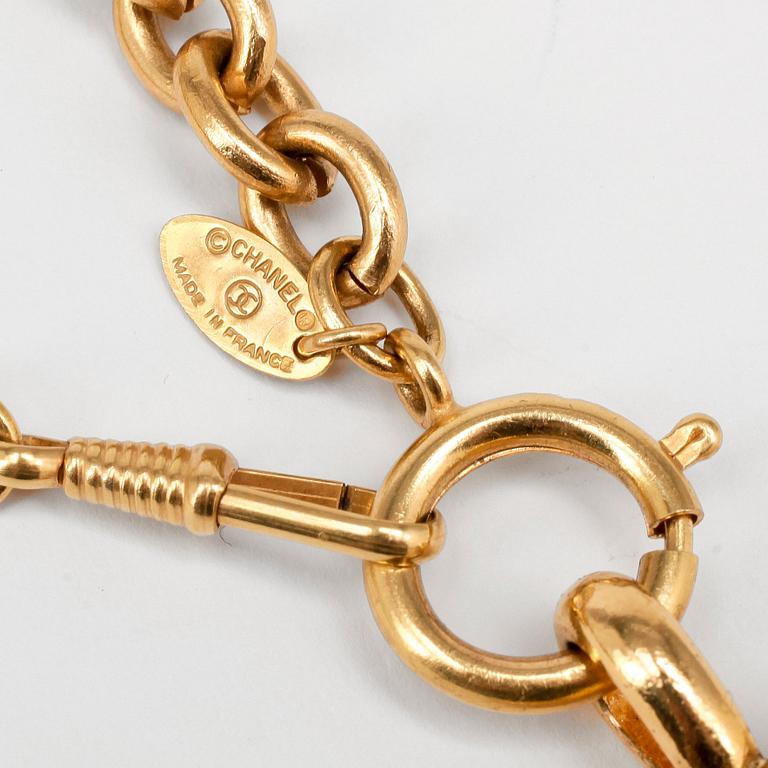 CHANEL a gold colored chain with pendant.