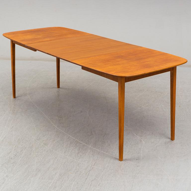 A late 20th Century teak veneered dinner table.