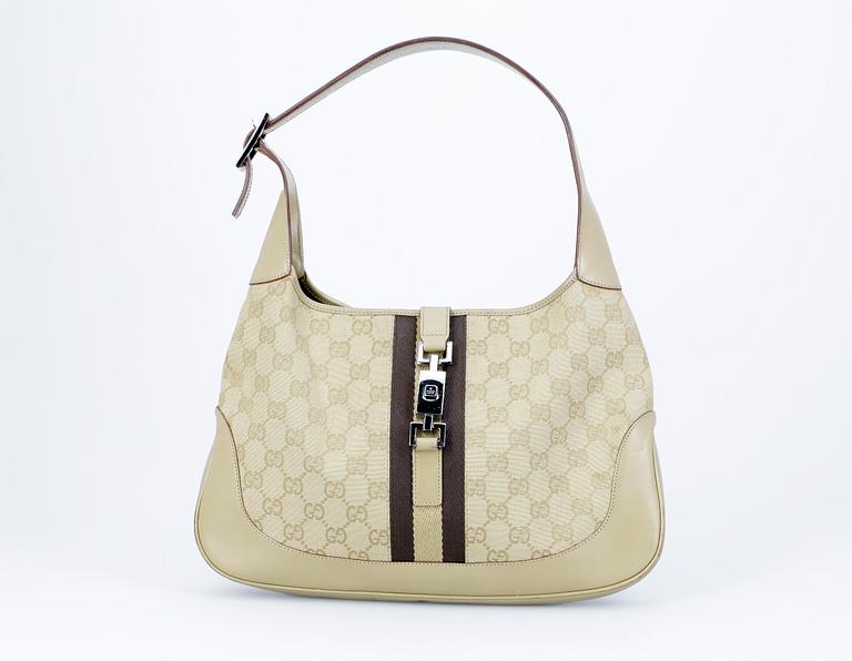 A beige monogram canvas handbag by Gucci.