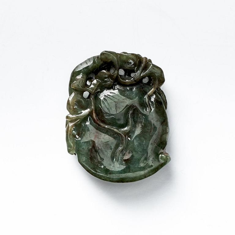 A Chinese green stone carving/pendant with a monkey and a bat by a peach.