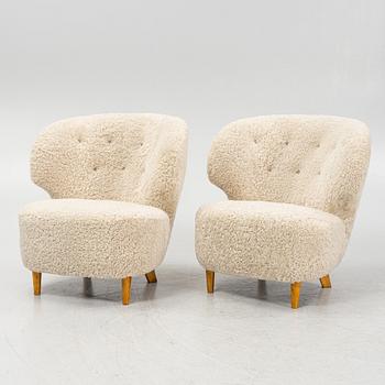 A pair of Scandinavian Modern 1940s cheepskin armchairs.