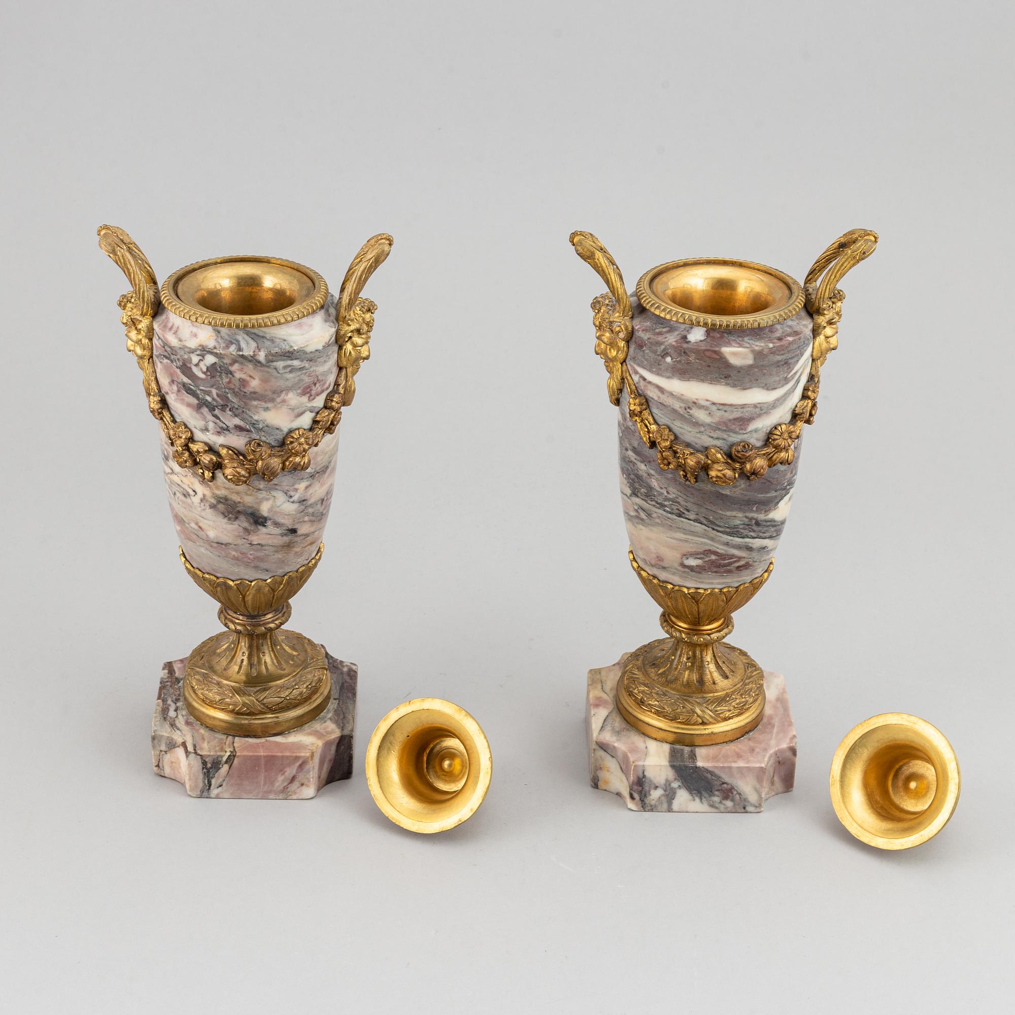 A pair of marble urns with bronze mountings from around year 1900.