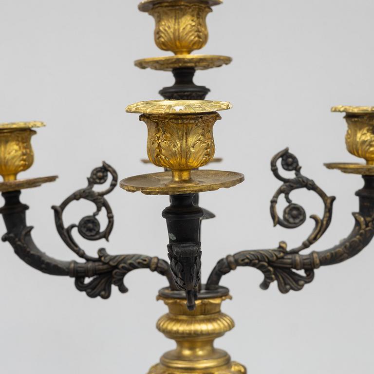 A pair of French Empire-style patinated and gilt bronze five-light candelabra, later part 19th century.