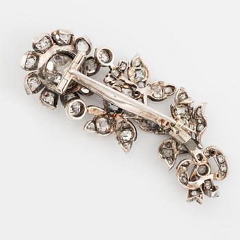 A flower silver brooch set with old-cut diamonds.