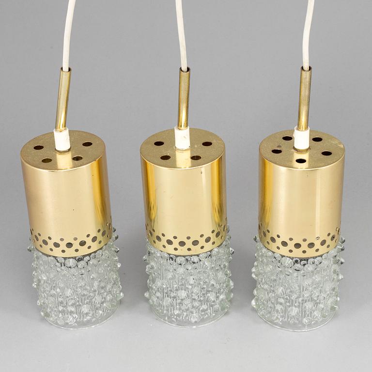 Three brass and glass pendant lights, 1960's.