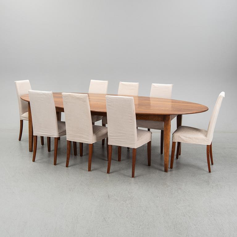 An stained oak dining table with eight chairs.