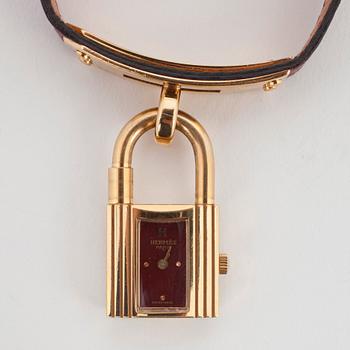 HERMÈS, a burgundy red leather braclet with 14k gold plated watch, "Kelly Lock".
