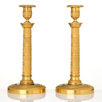 A pair of French Empire gilt-bronze candlesticks, early 19th century.
