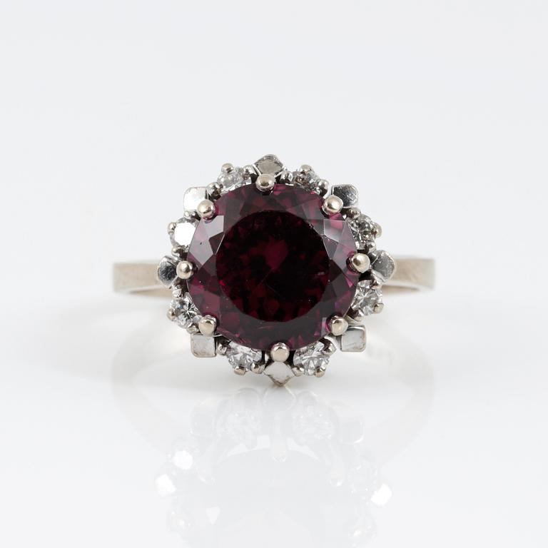 RING, 18K vitguld med fasetterad granat tot ca 3,68 cts omgiven av briljantslipade diamanter tot ca 0,4 ct. Vikt 6,91 g.