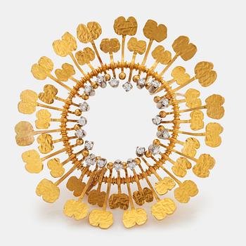 A Tapio Wirkkala  "Diamond sun" brooch in 18K gold set with round brilliant-cut diamonds.