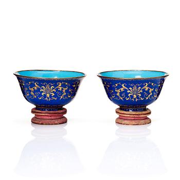 A pair of gilt decorated blue ground painted enamel bowls, Qianlong four character seal mark and period (1736-95).