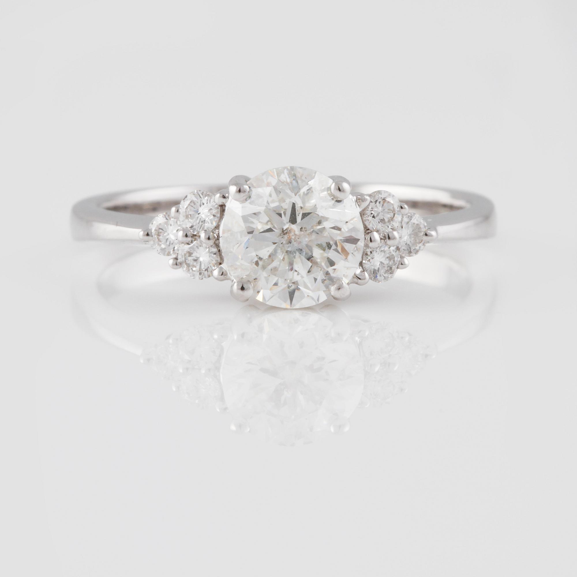 RING, 18K vitguld med briljantslipad diamant ca 0.97 ct och små briljantslipade diamanter ca 0.16 ct. Vikt 2,6 gram.