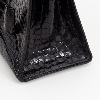 1962 black alligator 'Kelly' handbag by Hermès.